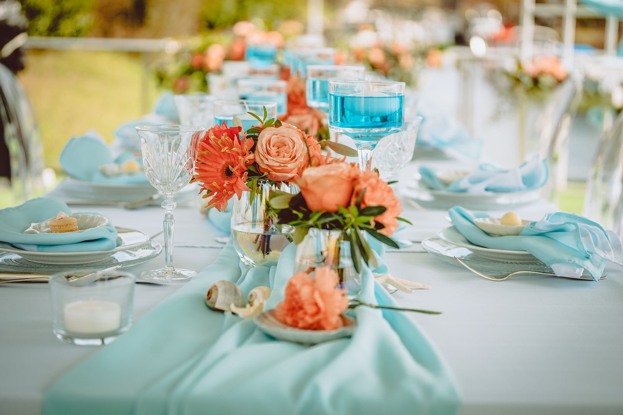Eine Tischdekoration mit blauen und orangefarbenen Blumen.