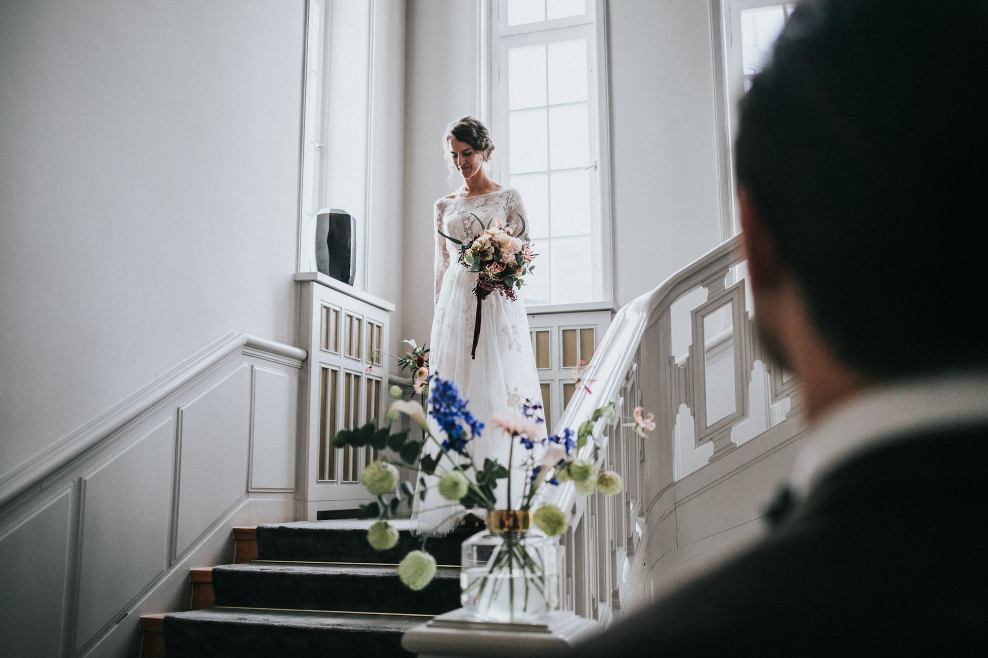 Eine Braut und ein Bräutigam stehen auf der Treppe eines Gebäudes.