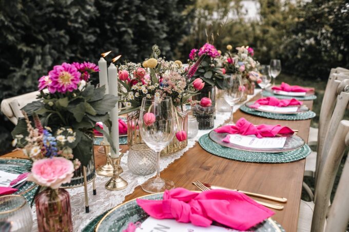 Ein mit rosa Tellern und Servietten gedeckter Tisch.
