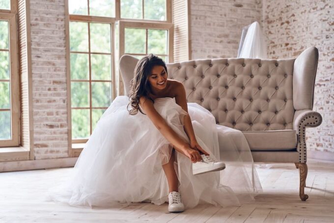 Eine Braut in einem weißen Kleid sitzt auf einer Couch.
