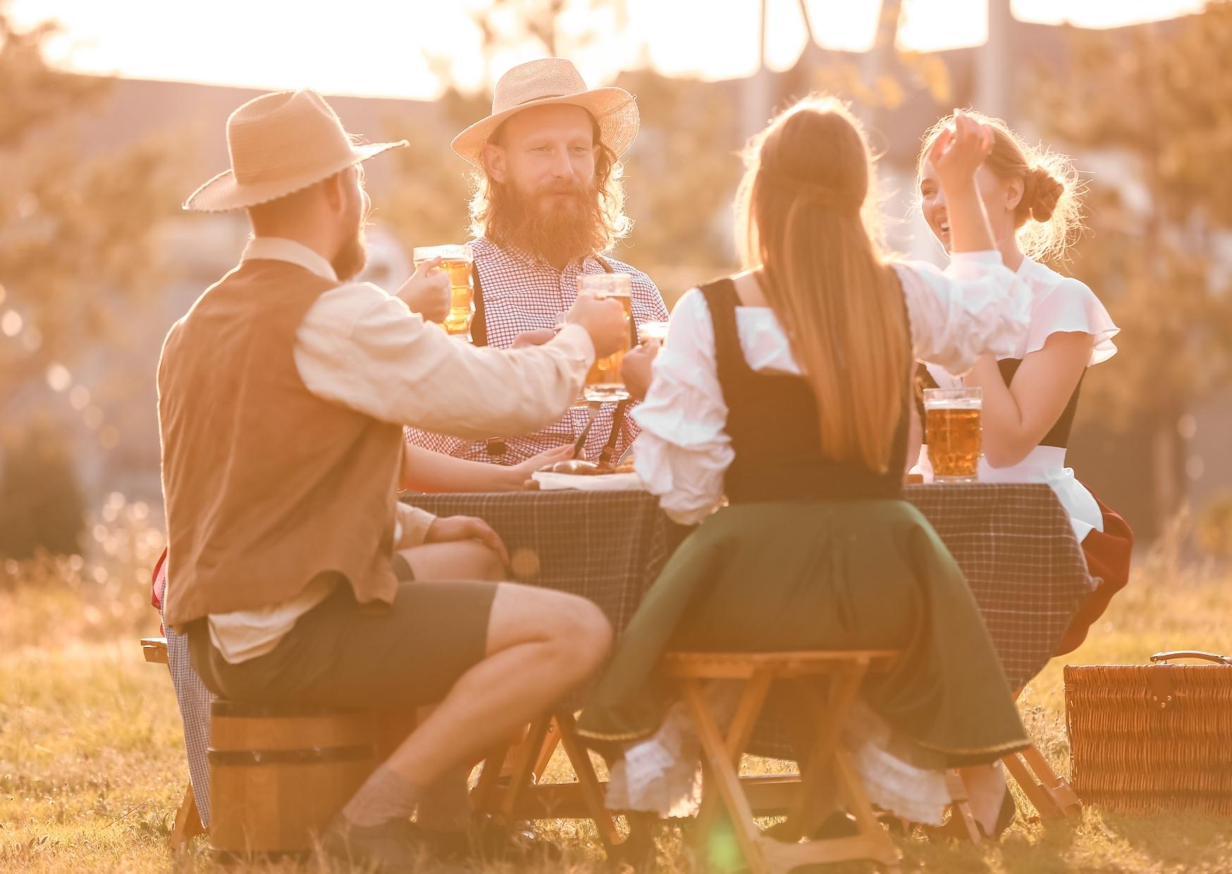 Eine Gruppe von Menschen sitzt an einem Tisch und trinkt Bier.