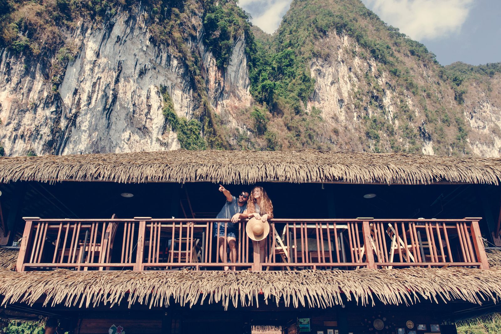 Ein Paar steht auf dem Balkon einer Hütte in der Nähe eines Berges.
