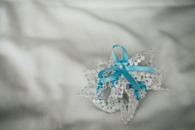 Eine blau-weiße Spitzenschleife auf einem weißen Bett.