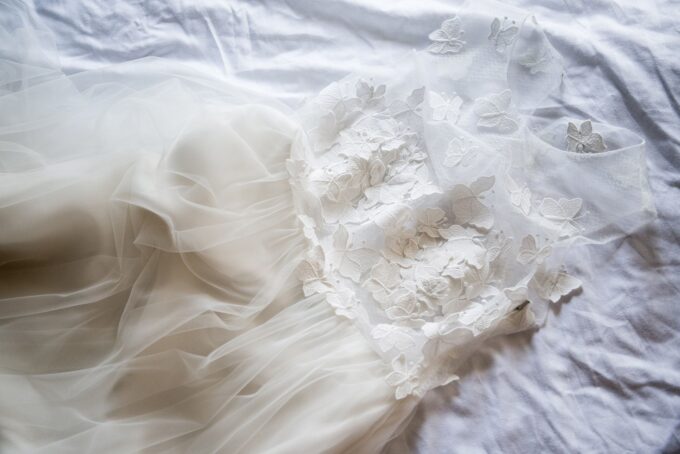 Ein Hochzeitskleid, das auf einem Bett liegt.