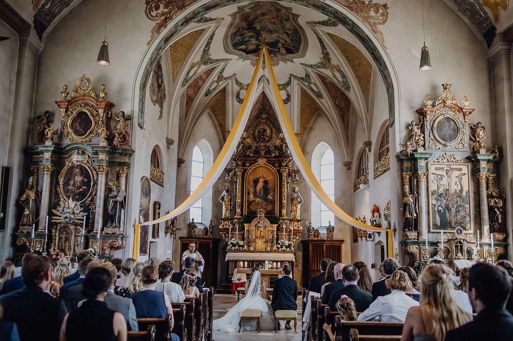 Eine Hochzeitszeremonie in einer reich verzierten Kirche.