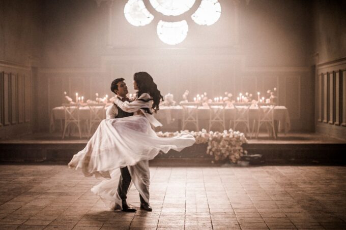 Eine Braut und ein Bräutigam tanzen in einem dunklen Raum.