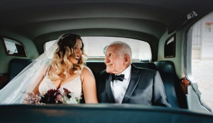 Eine Braut und ihr Großvater auf dem Rücksitz eines Autos.