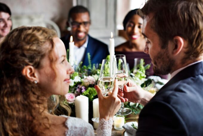 Eine Gruppe von Menschen prostet bei einer Hochzeitsfeier mit Champagner an.