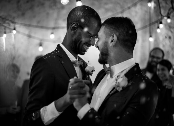 Schwarz-Weiß-Foto von zwei Männern, die auf einer Hochzeit tanzen.