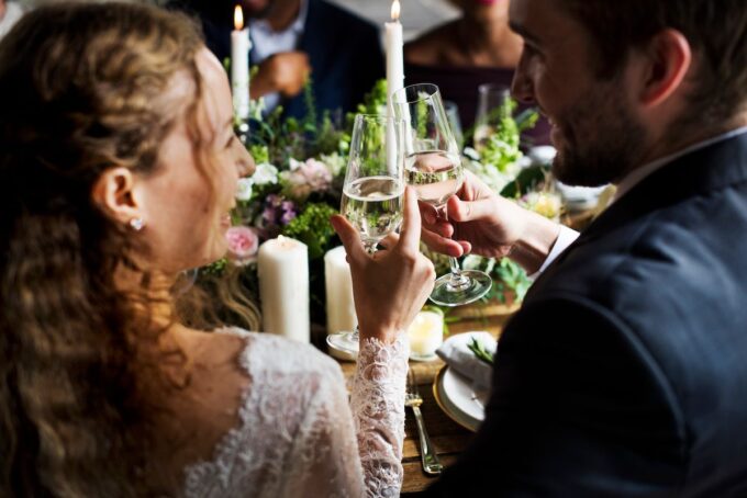 Eine Braut und ein Bräutigam stoßen bei einer Hochzeitsfeier mit Champagner an.