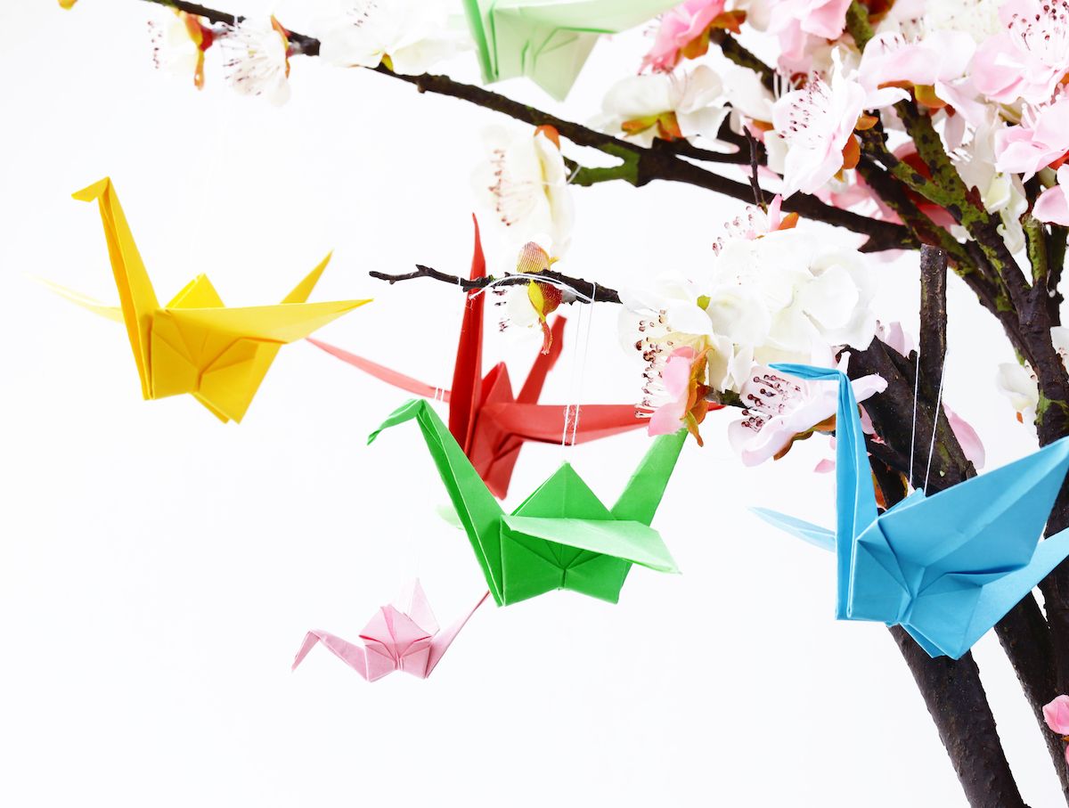 Origami-Kraniche hängen an einem Baum.