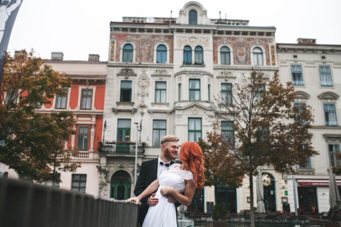 Eine Braut und ein Bräutigam küssen sich vor einem Gebäude.