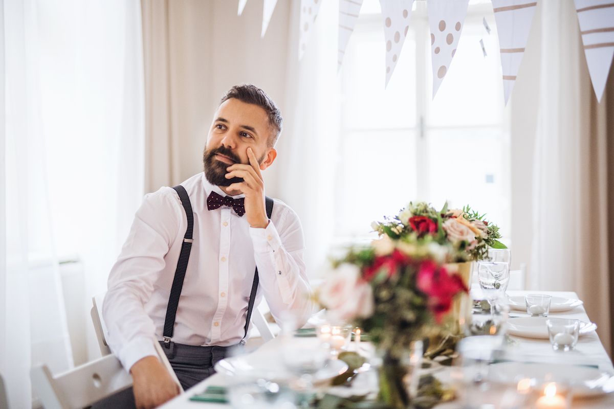 Ein Mann mit Bart telefoniert, während er an einem Tisch sitzt.