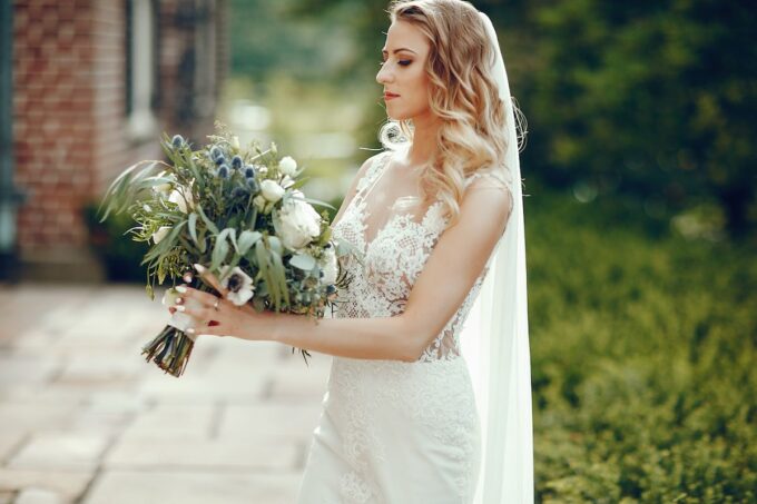 Eine Braut in einem Hochzeitskleid, die einen Blumenstrauß hält.
