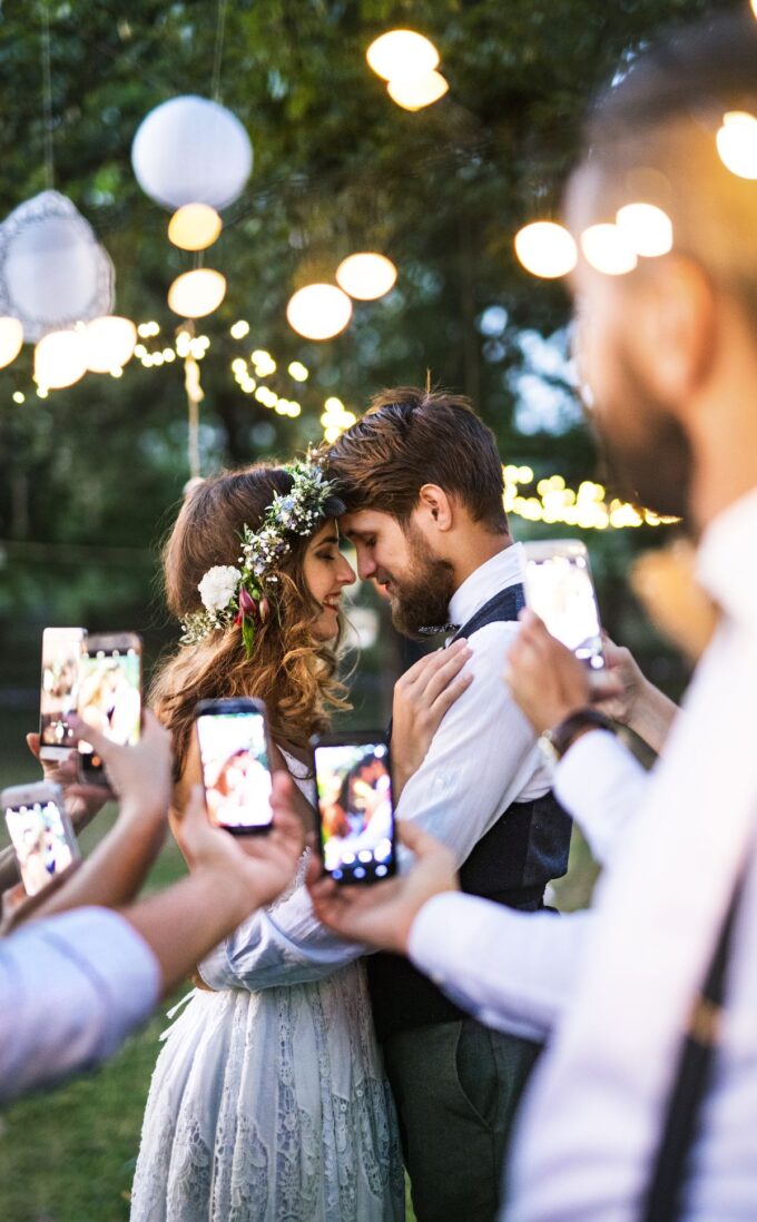 Ein Brautpaar macht Fotos mit ihren Mobiltelefonen.