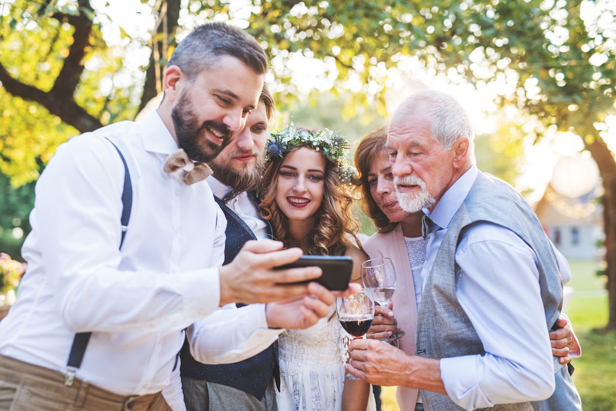 Eine Gruppe von Menschen, die mit einem Mobiltelefon ein Foto machen.