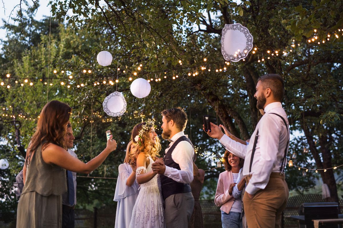 Eine Gruppe Braut und Bräutigam wirft Papierlaternen in die Luft.