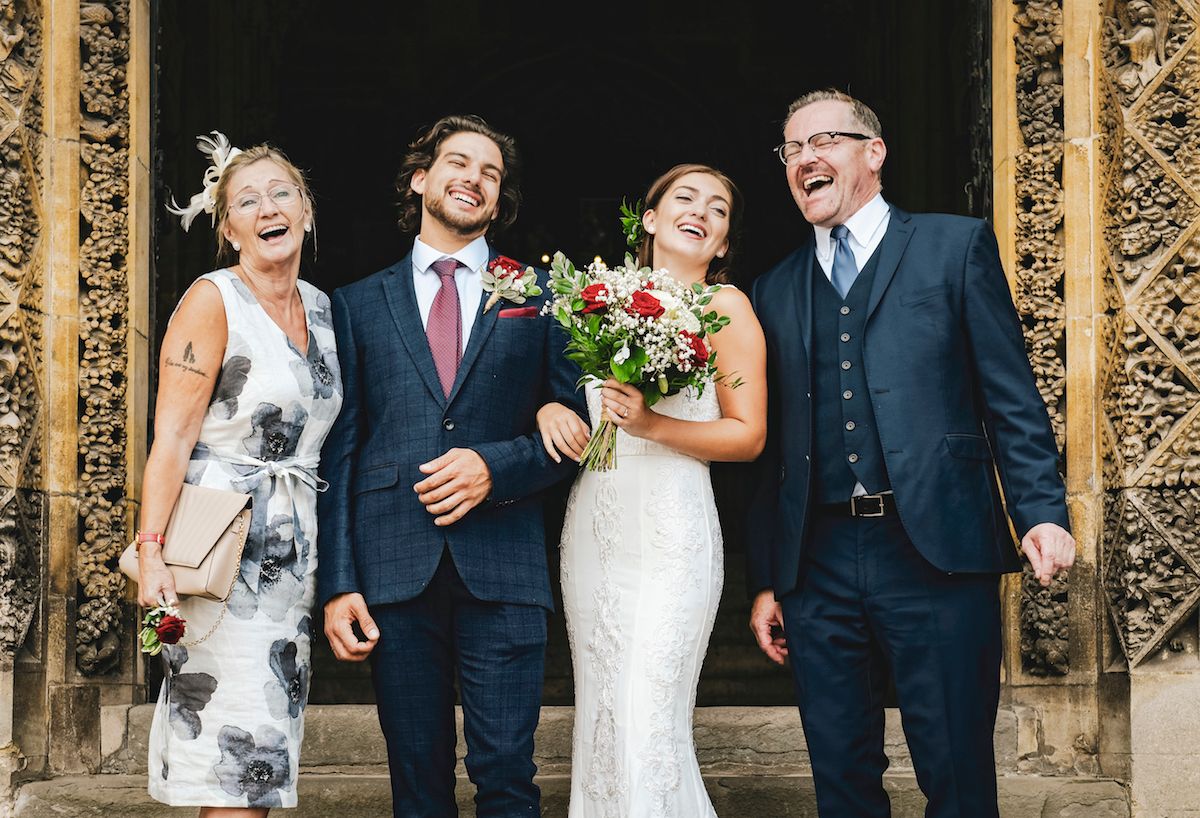 Ein Brautpaar mit seiner Familie vor einer Kirche.