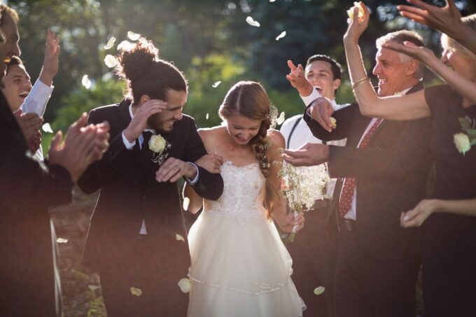Eine Braut und ein Bräutigam bewerfen sich gegenseitig mit Konfetti.