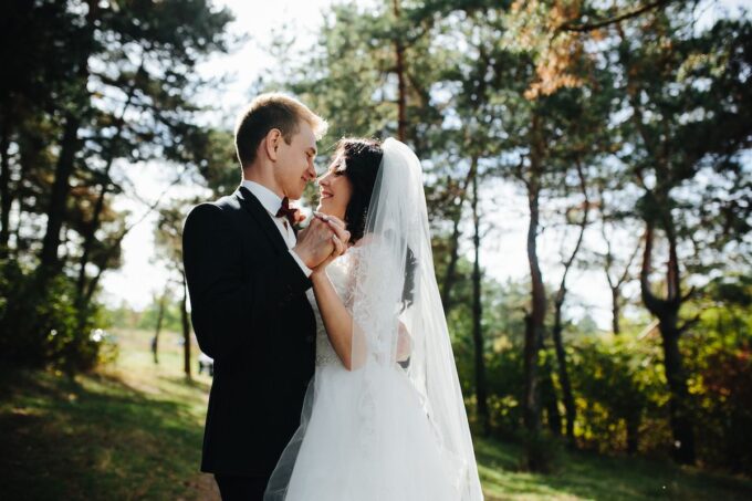 Eine Braut und ein Bräutigam umarmen sich im Wald.
