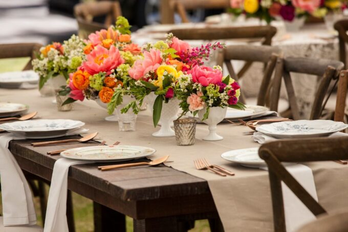 Ein mit bunten Blumen und Tellern gedeckter Tisch.