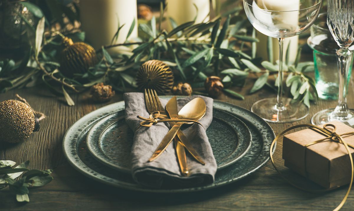 Ein weihnachtlich gedeckter Tisch mit einer goldenen Gabel und Besteck.