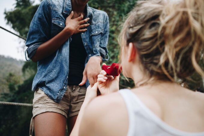 Eine Frau schenkt einem Mädchen eine rote Rose.