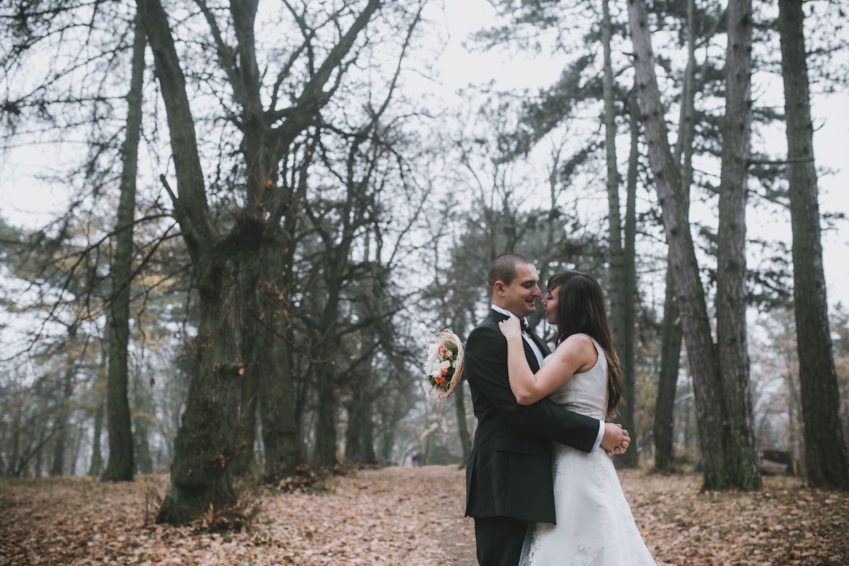Eine Braut und ein Bräutigam umarmen sich im Wald.