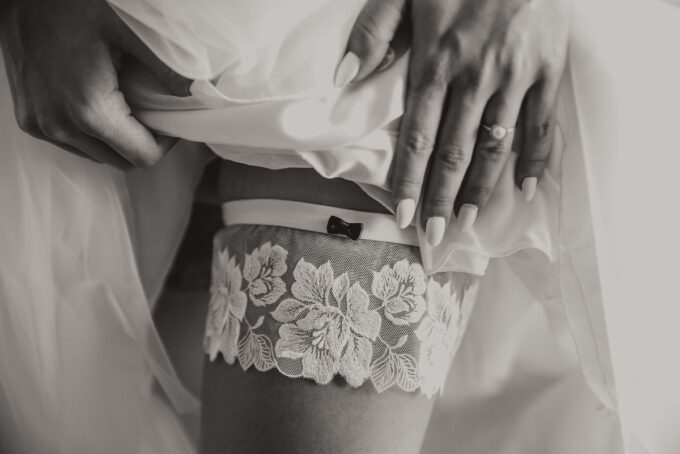 Ein Schwarz-Weiß-Foto einer Braut, die ein Strumpfband trägt.