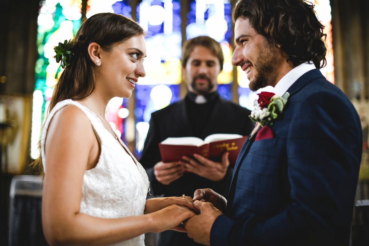 Eine Braut und ein Bräutigam tauschen ihre Eheringe in einer Kirche.
