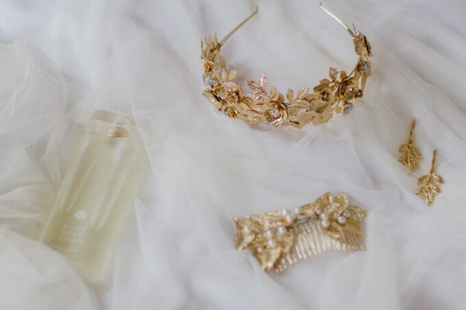 Eine goldene Tiara und andere Accessoires auf einem weißen Tuch.