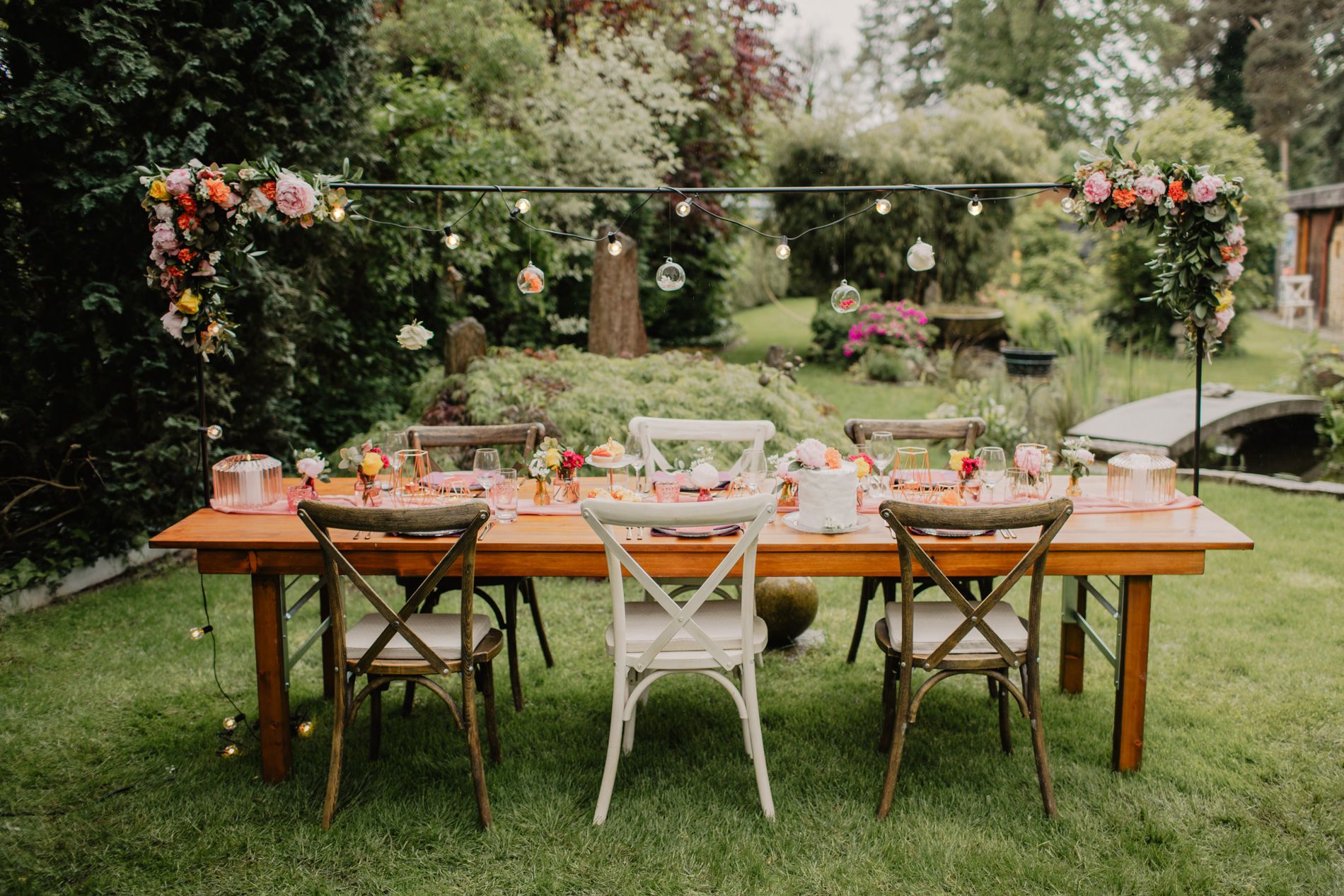 Ein Tisch in einem Garten mit Stühlen und Blumen.
