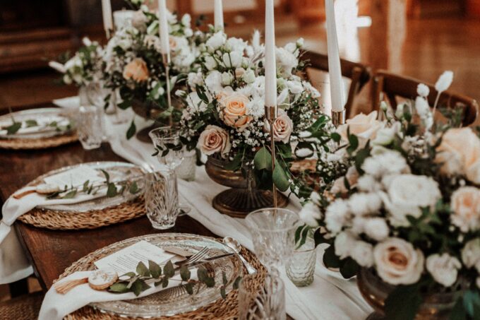 Ein gedeckter Tisch mit Kerzen und Blumen.