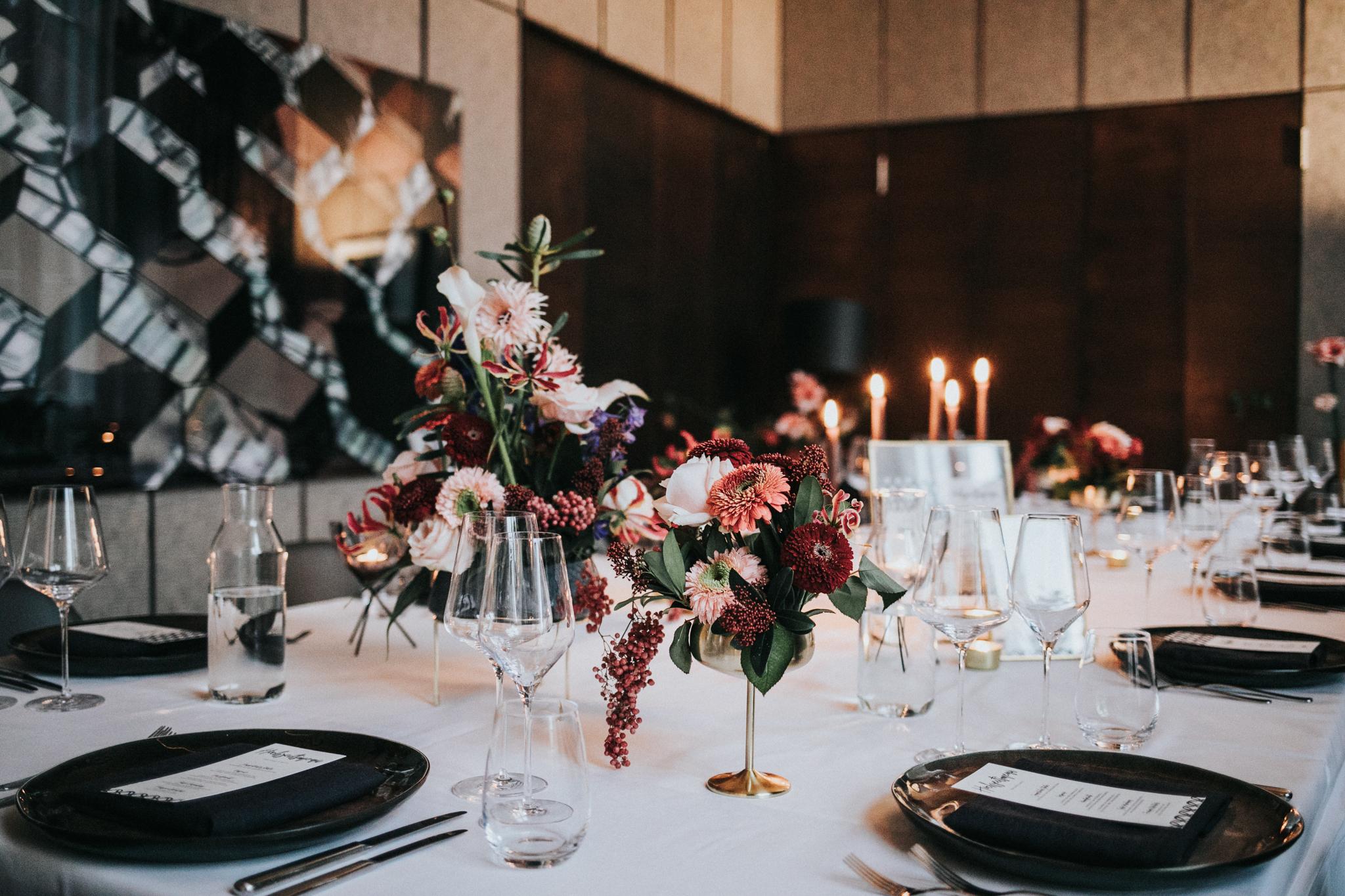 Eine schwarz-weiße Tischdekoration mit Blumen und Kerzen.