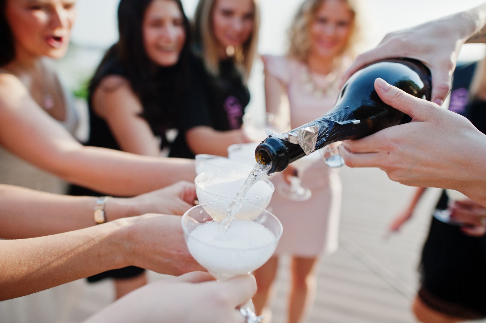 Eine Gruppe Frauen gießt Champagner in Gläser.