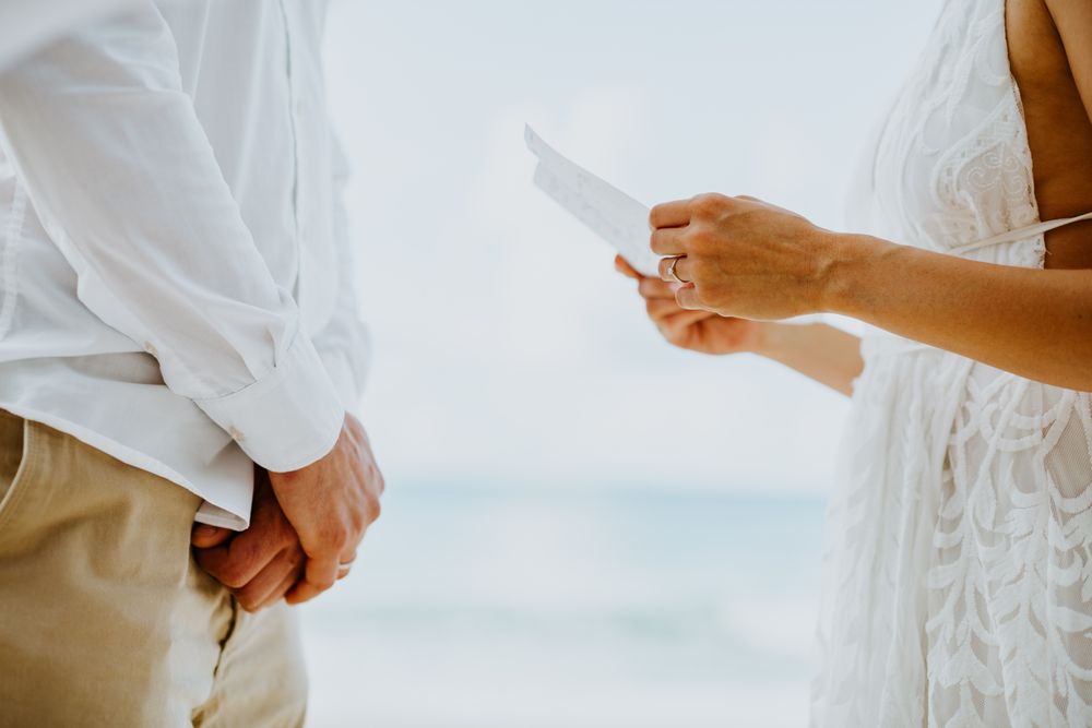 Eine Braut und ein Bräutigam schauen sich am Strand an.