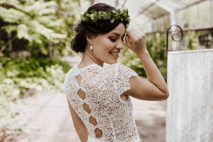 Eine Braut in einem Spitzenkleid mit einer Blumenkrone.