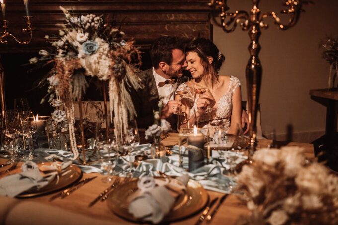 Eine Braut und ein Bräutigam teilen sich bei ihrer Hochzeitsfeier ein Glas Champagner.