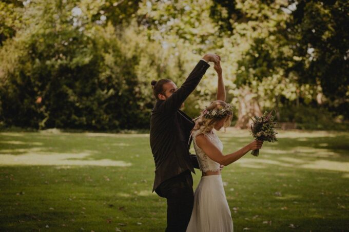Eine Braut und ein Bräutigam tanzen auf einem Feld.