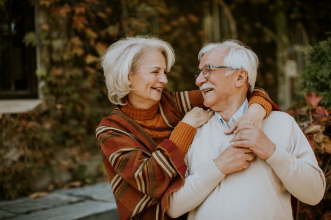 Älteres Paar umarmt sich im Herbst.