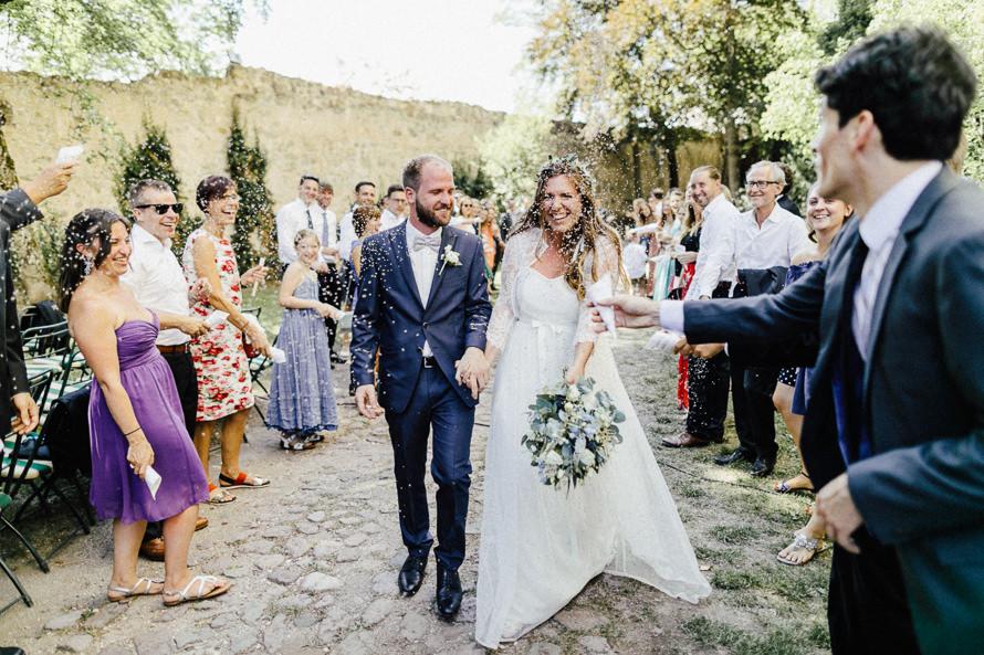 Eine Braut und ein Bräutigam gehen einen Steinweg entlang.