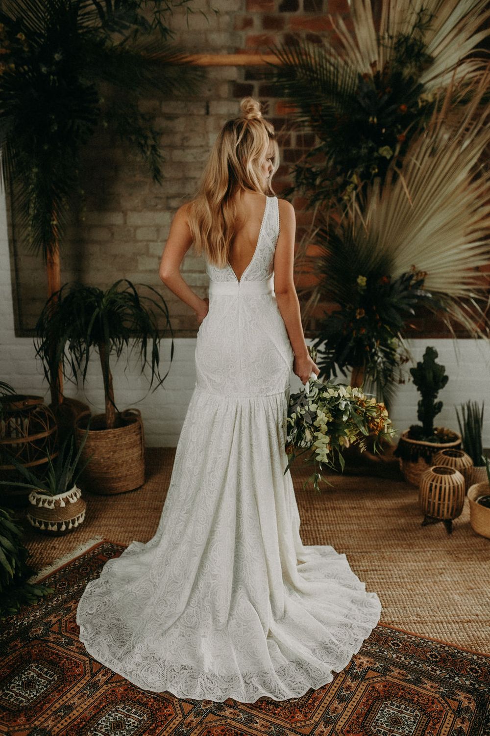 Die Rückansicht einer Braut in einem weißen Spitzenhochzeitskleid.