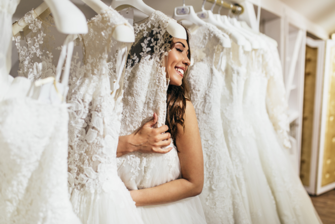 Eine Braut schaut sich Brautkleider in einem Brautmodengeschäft an.