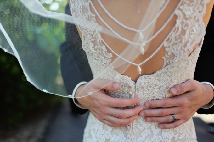 Eine Braut und ein Bräutigam umarmen sich in einem Hochzeitskleid.