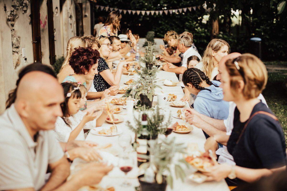 Eine Gruppe von Menschen isst an einem langen Tisch.