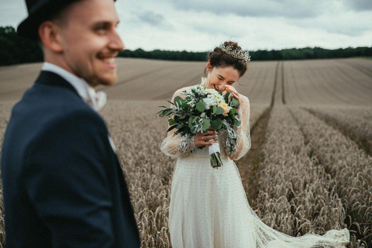 Eine Braut und ein Bräutigam stehen auf einem Feld.
