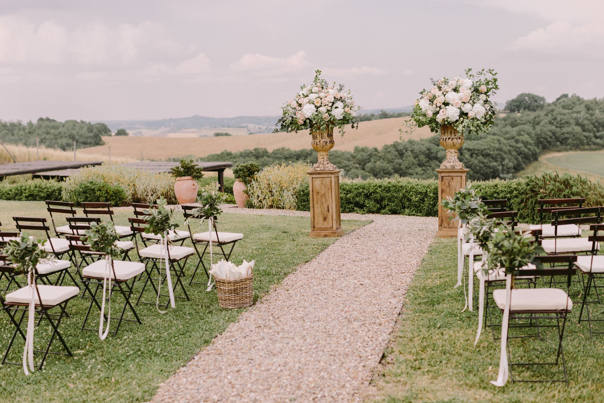 Eine Hochzeitszeremonie im Freien mit Stühlen und Blumen.