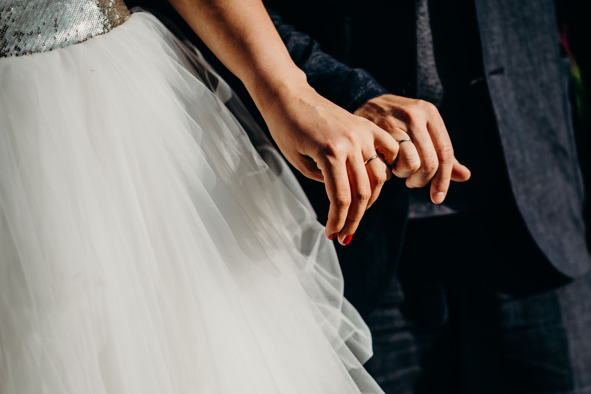 Hochzeitstage: Hände und Eheringe eines Brautpaares