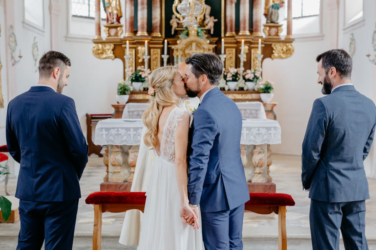 Ein Brautpaar küsst sich vorm Altar