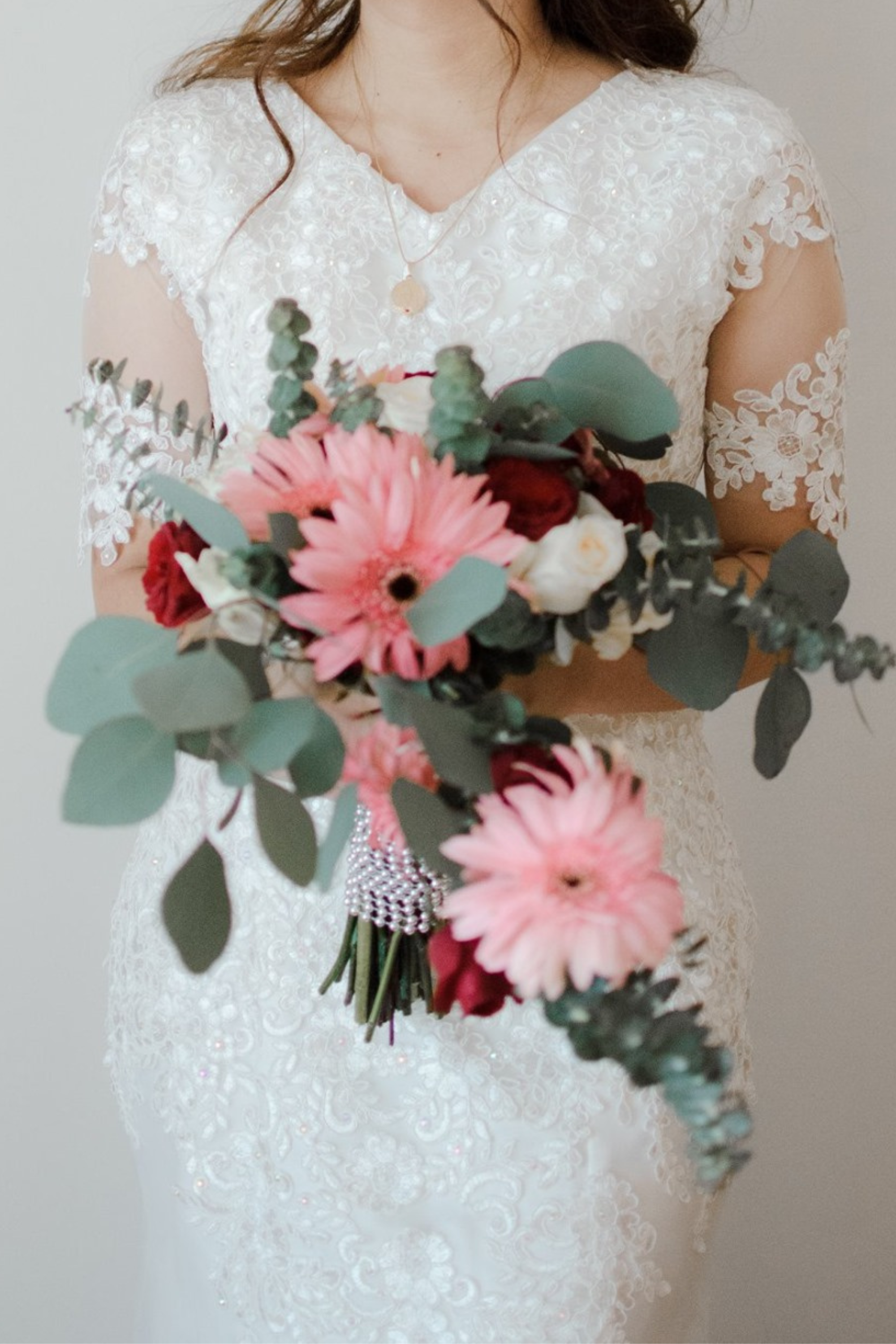 Die Braut trägt einen Brautstrauß mit Eukalyptus.